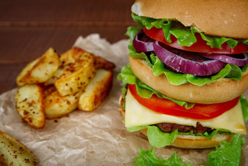 Big burger with fries on wooden