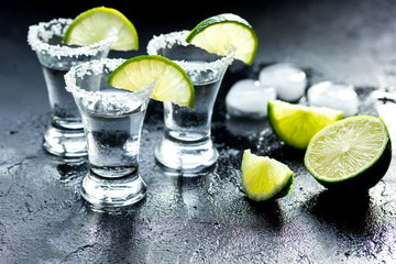 Tequila shot with salt and ice on dark background