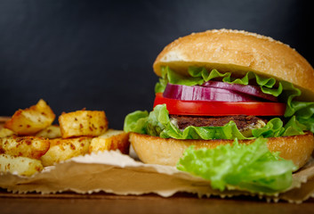 Big burger with fries on dark