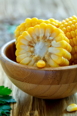 Slices of boiled corn cob in a wooden bowl closeup.