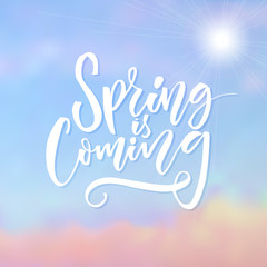 Naklejka na ściany i meble Spring is coming. Inspirational caption at blue sky background with sun. Brush lettering design.