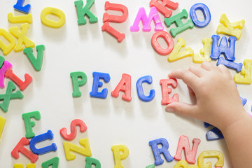 Little girl learning to write using magnetic letters. Learn Study Education School Knowledge Concept