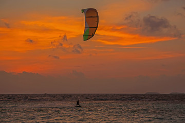 Kite surfing against majestic fiery sunset