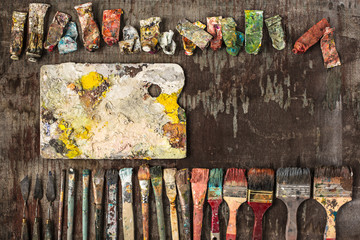 paint brushes and tubes of oil paints on wooden background