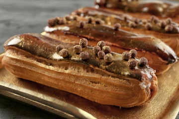 Delicious eclairs on metal tray closeup