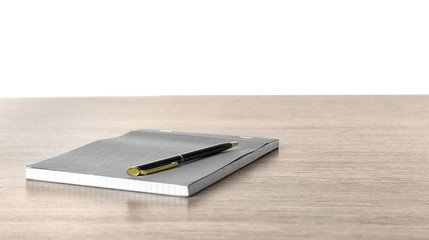 Notebook with pen on wooden desk