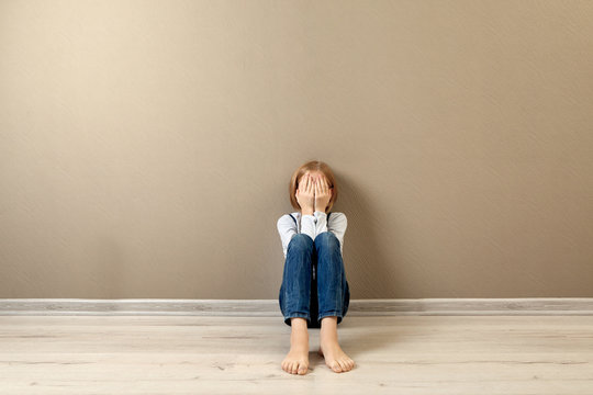 Upset girl sitting on the floor at home