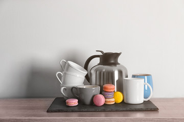 Thermos kettle with cups and macaroons on slate plate
