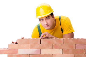 Handsome construction worker building brick wall