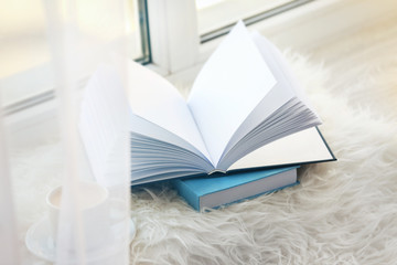 Cup of coffee and books on windowsill
