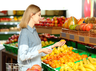 Beautiful woman buying fruits in market