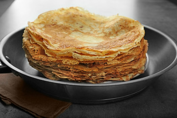 Pile of tasty pancakes in frying pan