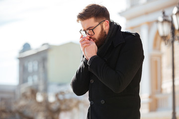 Man standing and bowing on hands outdoors in cold weather