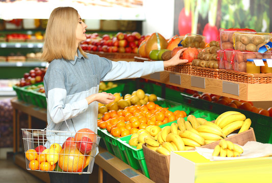 Beautiful woman buying fruits in market