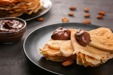 Delicious pancakes with banana and chocolate on plate