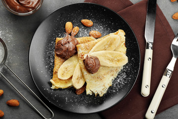 Delicious pancakes with banana and chocolate on plate
