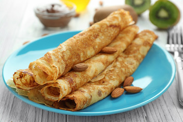 Blue plate with delicious pancakes on wooden table