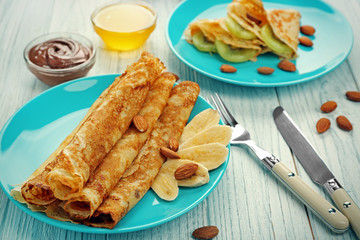 Blue plate with delicious pancakes on wooden table
