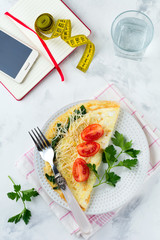 Omelet with spinach, parsley and cheese for breakfast on a light background. Selective focus.