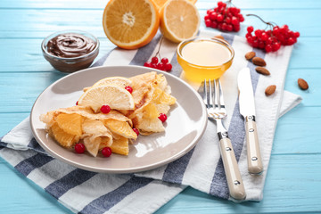 Tasty pancakes with citrus fruits and viburnum on white plate