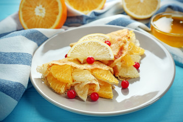 Tasty pancakes with citrus fruits and viburnum on white plate