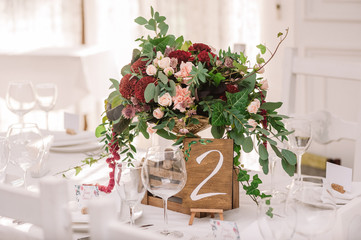 Wedding table decoration with the red and pink flowers and wooden box