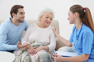 Obraz premium Nurse talking with grandmother and her grandson indoors