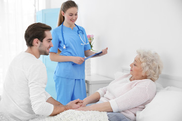Obraz premium Young man talking with grandmother and nurse