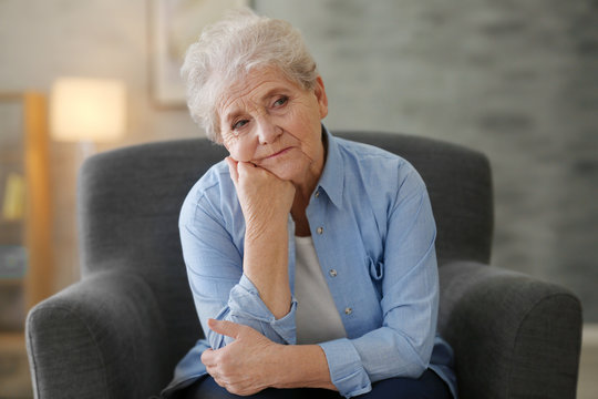 Depressed Elderly Woman Sitting In Arm-char At Home