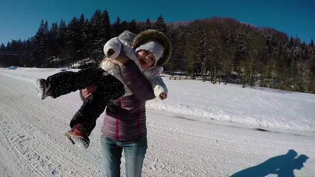 Mother and daughter having fun in winter. Slow motion
