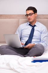 Businessman working in the bed at home