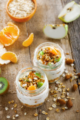 Granola with yogurt and fruits in a rustic jar. Delicious healthy American food for breakfast. Traditional US snack. Top view shot.