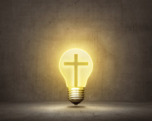 Christian cross inside bright bulb