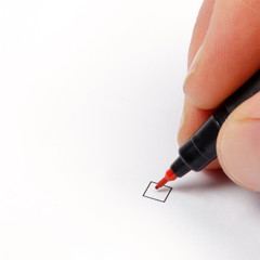Hand with red pen ready to mark a checkbox