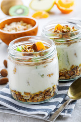Yogurt, granola and fruits in a jars for delicious breakfast. Traditional American healthy food.