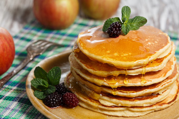 Homemade pancakes with honey and berry fruit. Closeup, selective focus.