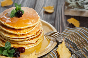 Homemade pancakes with honey and berry fruit. Closeup, selective focus.