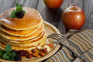 Homemade pancakes with honey and berry fruit. Closeup, selective focus.