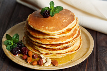 Homemade pancakes with honey and berry fruit. Closeup, selective focus.