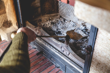 Cleaning  fireplace. Hand holding  shovel with ash