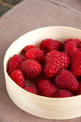 Fresh raspberries in a wooden round box