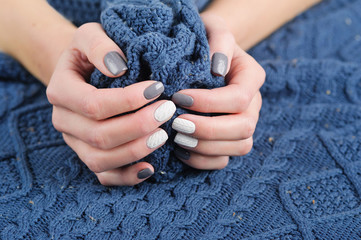 Woman hands with beautiful winter trend knit sweater manicure