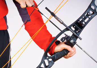 Hands of a person grabbing a compound bow and archery release