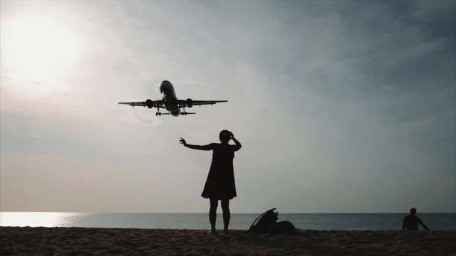 spotting. plane flies very low over the beach. thailand. at sunset, silhouette. 