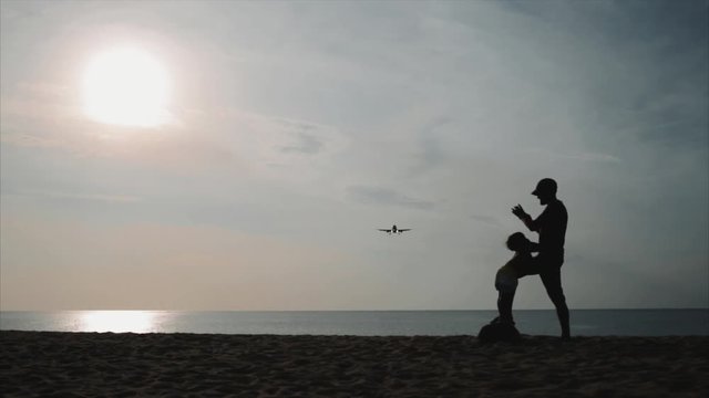 spotting. plane flies very low over the beach. thailand. at sunset, silhouette.