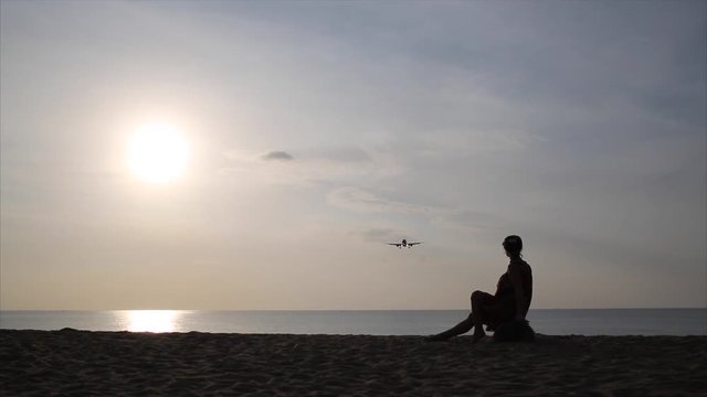 spotting. at sunset, people watch as the plane lands. plane flies very low over the beach. thailand 
