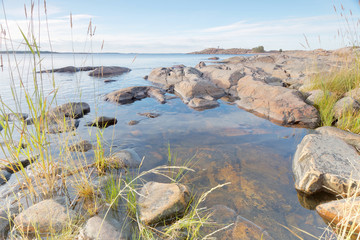 Rocky coastline, grass in the foreground and blue sea
