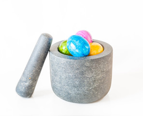 Bunte Ostereier in einem Granit Mörser vor weißem Hintergrund