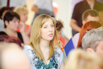 young pensive woman in the crowd