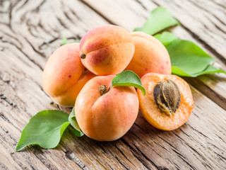 Apricots and its cross-section on the old wooden table.